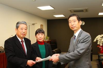 答申書を守本市長に手渡した原委員長(左)と清川副委員長(中央)